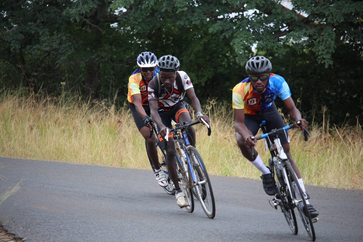 Cyclists riding through green terrain